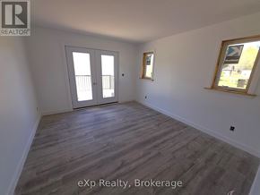 South Bruce multi-family for rent - A room with a sliding door and a window with a view of a tree.