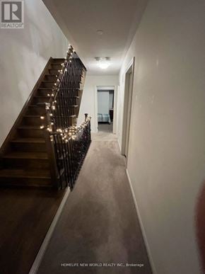 Oshawa (Windfields) townhouse for rent - A hallway with a staircase and lights on the banister.
