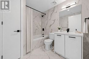 Toronto (Moss Park) condo for rent - A bathroom with a marble wall and a white toilet.