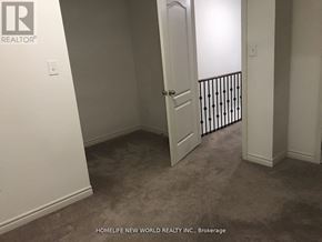 Oshawa (Windfields) townhouse for rent - A room with a carpeted floor and a white door.