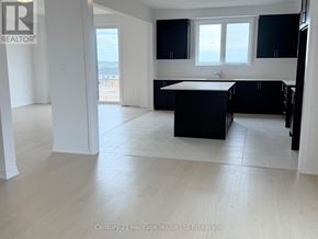 South-West Oxford apartment for rent - A spacious kitchen with black cabinets and a white island.