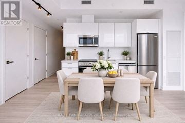 Toronto (Moss Park) condo for rent - A modern kitchen with a dining table set for four.