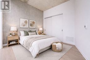 Toronto (Moss Park) condo for rent - A bedroom with a large bed, two lamps, and a basket on the floor.