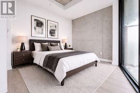 Toronto (Moss Park) condo for rent - A bedroom with a large bed, two nightstands, and a window.
