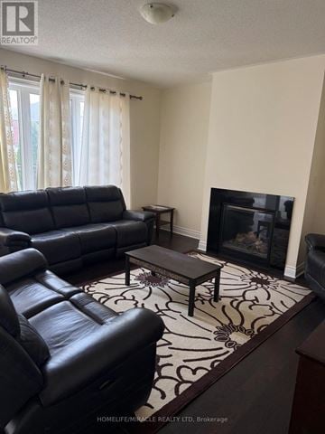 Brampton (Credit Valley) apartment for rent - A black leather couch sits in a living room with a fireplace.