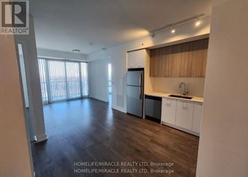 Brampton (Northwest Brampton) condo for rent - A spacious kitchen with a refrigerator, sink, and cabinets is shown in this image.
