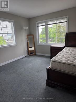 Brampton (Brampton West) apartment for rent - A bedroom with a bed, dresser, and window.