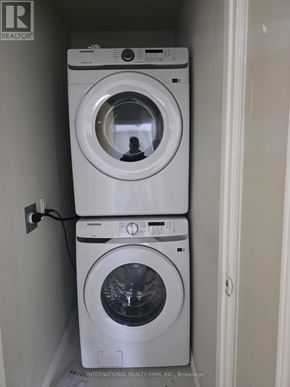 Brampton (Brampton West) apartment for rent - Two white front loading washing machines in a small laundry room.
