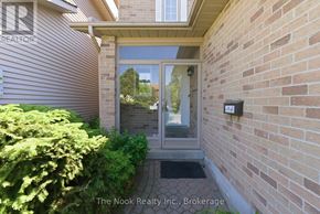 Oshawa (Pinecrest) apartment for rent - A brick wall with a glass door and a small bush in front.