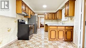 Toronto (Pleasant View) apartment for rent - A kitchen with a black fridge and wooden cabinets.