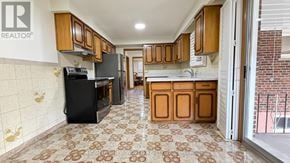 Toronto (Pleasant View) apartment for rent - A kitchen with a black refrigerator and wooden cabinets.