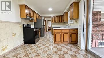 Toronto (Pleasant View) apartment for rent - A kitchen with a black refrigerator and wooden cabinets.