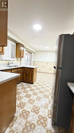 Toronto (Pleasant View) apartment for rent - A kitchen with a refrigerator, sink, and patterned floor tiles.