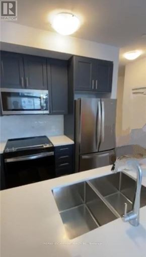 Hamilton (Waterdown) condo for rent - A kitchen with a white counter top and a stainless steel sink.