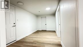 Toronto (Pleasant View) apartment for rent - A white door is on the left side of a room with wooden floors and white walls.