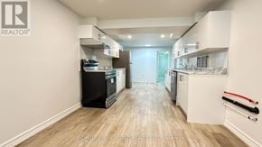 Toronto (Pleasant View) apartment for rent - A well-lit kitchen with a refrigerator, oven, and cabinets.