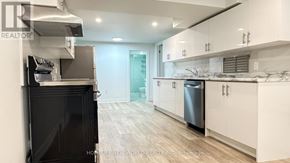 Toronto (Pleasant View) apartment for rent - A modern kitchen with white cabinets and a black stove top oven.