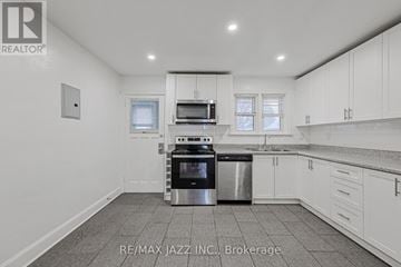 Oshawa (O'neill) multi-family for rent - A kitchen with white cabinets and a stainless steel dishwasher and oven.
