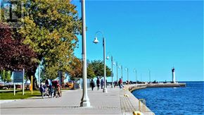 Oakville (Br Bronte) condo for rent - A sunny day at the waterfront with people walking and cycling.