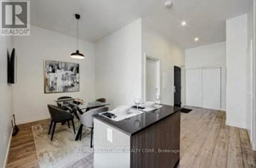 Oakville (Br Bronte) condo for rent - A modern kitchen with a dining table and chairs.