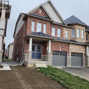 Brampton (Northwest Brampton) townhouse for rent - A brick house with a blue door and two garage doors.