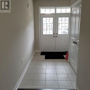 Brampton (Northwest Brampton) townhouse for rent - A hallway with a black doormat and a sign on the door.