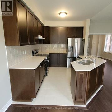 Brampton (Northwest Brampton) townhouse for rent - A kitchen with brown cabinets and a white countertop.