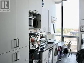 Oshawa (Samac) condo for rent - A kitchen with white cabinets and a black stove top.