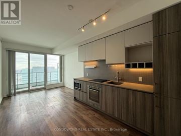 Vaughan (Concord) condo for rent - A modern kitchen with wooden cabinets and a large window.