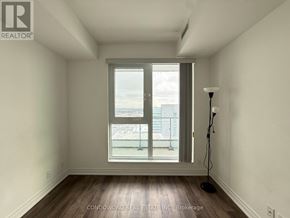 Vaughan (Concord) condo for rent - A room with a large window and a lamp on the floor.