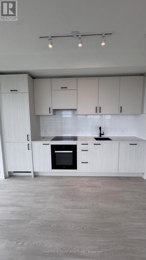 Toronto (Banbury-Don Mills) condo for rent - A kitchen with white cabinets and a black oven.