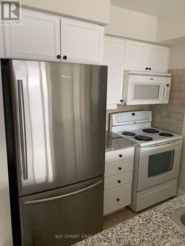Toronto (Newtonbrook West) condo for rent - A kitchen with a stainless steel refrigerator and a white microwave oven.