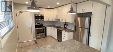 Guelph (St. George's) apartment for rent - A kitchen with white cabinets and a stainless steel refrigerator.