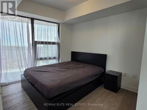Toronto (Bay Street Corridor) condo for rent - A bedroom with a large bed and a window with curtains.