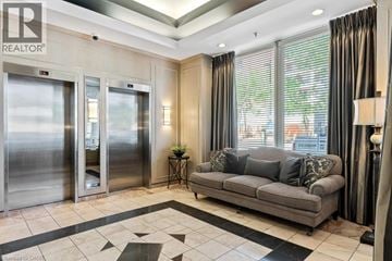Burlington condo for rent - A living room with a grey couch and a black and white checkered floor.