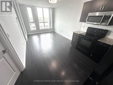 Toronto (West Humber-Clairville) condo for rent - A kitchen with black cabinets and a stove top oven.