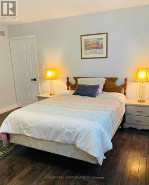 Niagara Falls (Forestview) apartment for rent - A bedroom with a bed, two lamps, and a picture on the wall.
