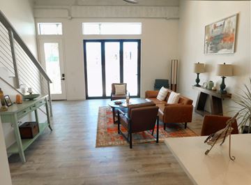 Pomona apartment for rent - A living room with a brown couch and a white table.