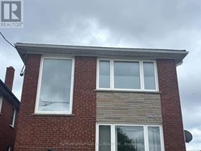 Toronto (Mimico) apartment for rent - A brick house with a sign that says "Sutton Group Realty, Brokerage".