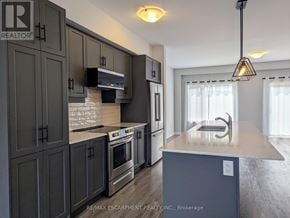 Hamilton (Mountview) townhouse for rent - A kitchen with dark cabinets and a stove top oven.