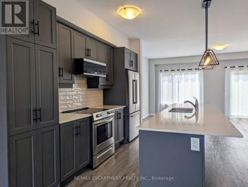 Hamilton (Mountview) townhouse for rent - A kitchen with dark cabinets and a stove top oven.