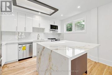 Aurora (Aurora Highlands) apartment for rent - A modern kitchen with white cabinets and a marble island.