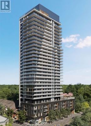 Burlington (Brant) condo for rent - A tall building with many windows and balconies is surrounded by trees.