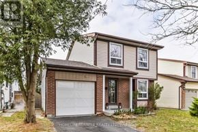 Ajax (South West) apartment for rent - A house with a garage door and a tree in front.