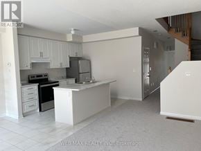 Oshawa (Windfields) townhouse for rent - A white kitchen with a refrigerator, oven, and sink.