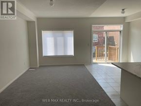 Oshawa (Windfields) townhouse for rent - A room with a large window and a view of a wooden fence and buildings outside.