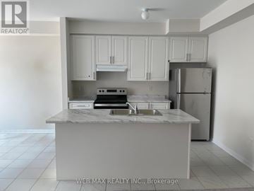 Oshawa (Windfields) townhouse for rent - A kitchen with white cabinets and a marble island.