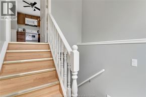 Lasalle apartment for rent - A staircase with a white railing leads to a kitchen area.