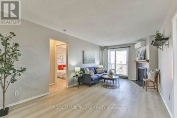 London South (South X) condo for rent - A living room with a grey couch and a fireplace.
