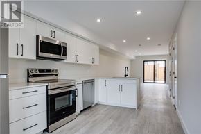 Sudbury apartment for rent - A modern kitchen with white cabinets and stainless steel appliances.